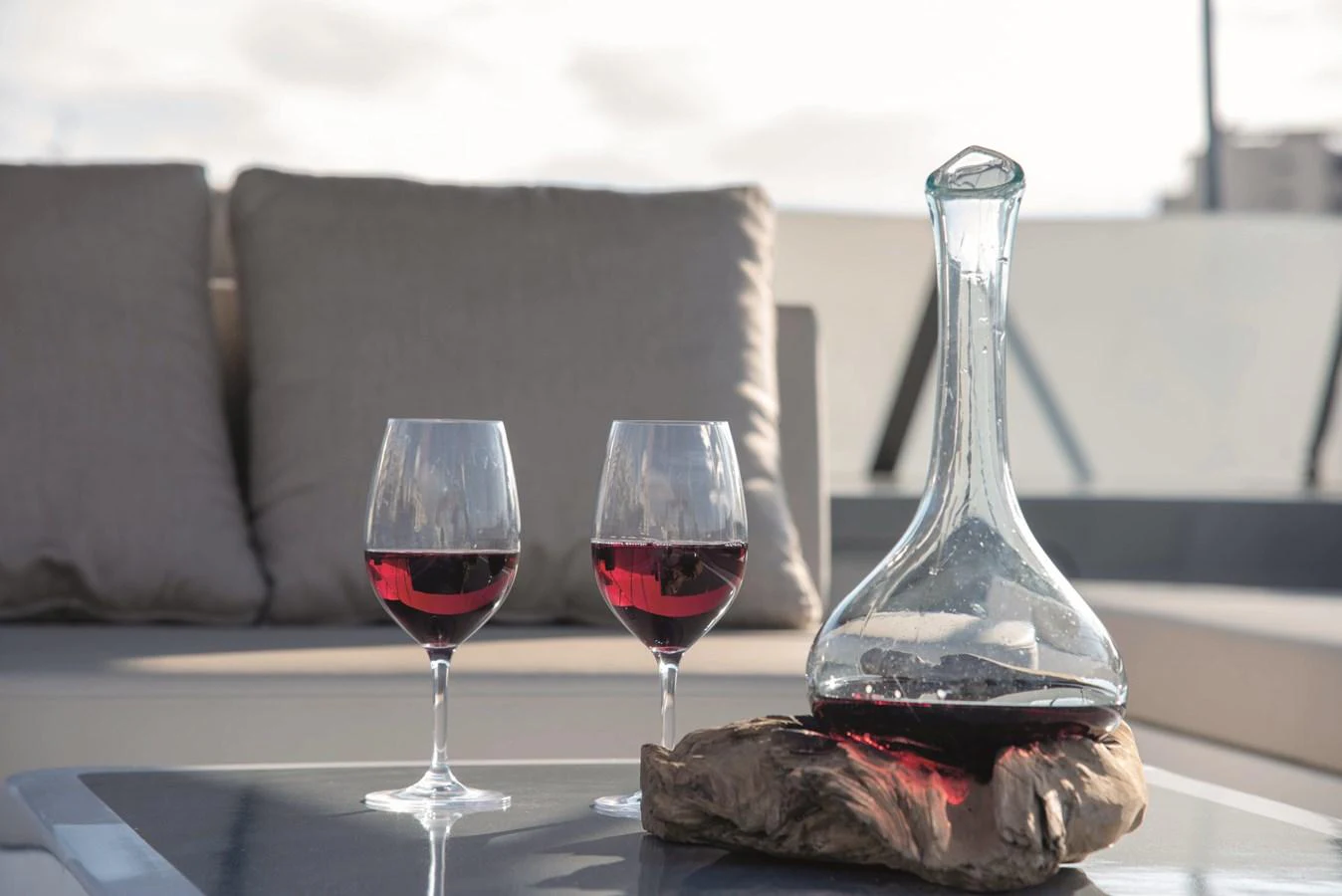 A serene setting with two glasses of red wine and a decanter on a yacht's deck. aboard KISS Yacht for Sale