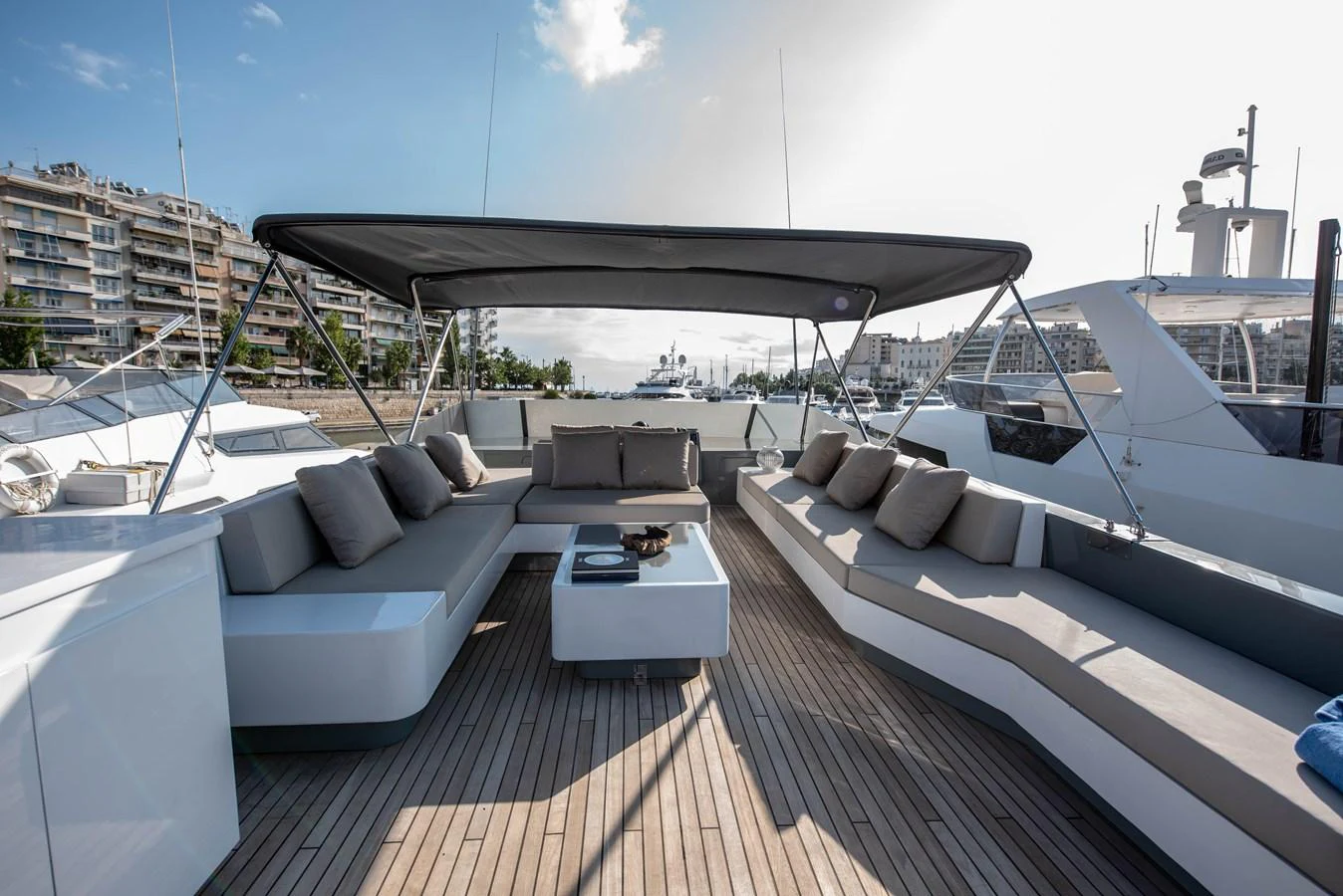 The yacht's aft deck features a spacious seating area with a sleek, modern design and ample shade. aboard KISS Yacht for Sale