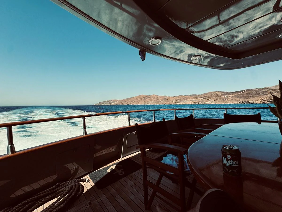 The aft deck offers a serene view of the open sea and distant coastline, perfect for relaxation and dining. aboard KISS Yacht for Sale