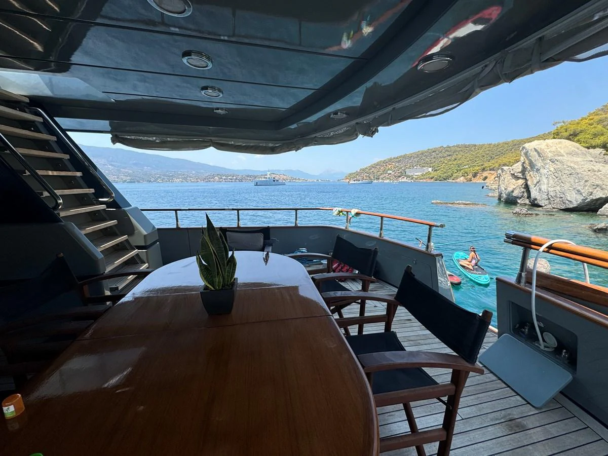The aft deck offers a spacious outdoor dining area with stunning views of the surrounding waters. aboard KISS Yacht for Sale