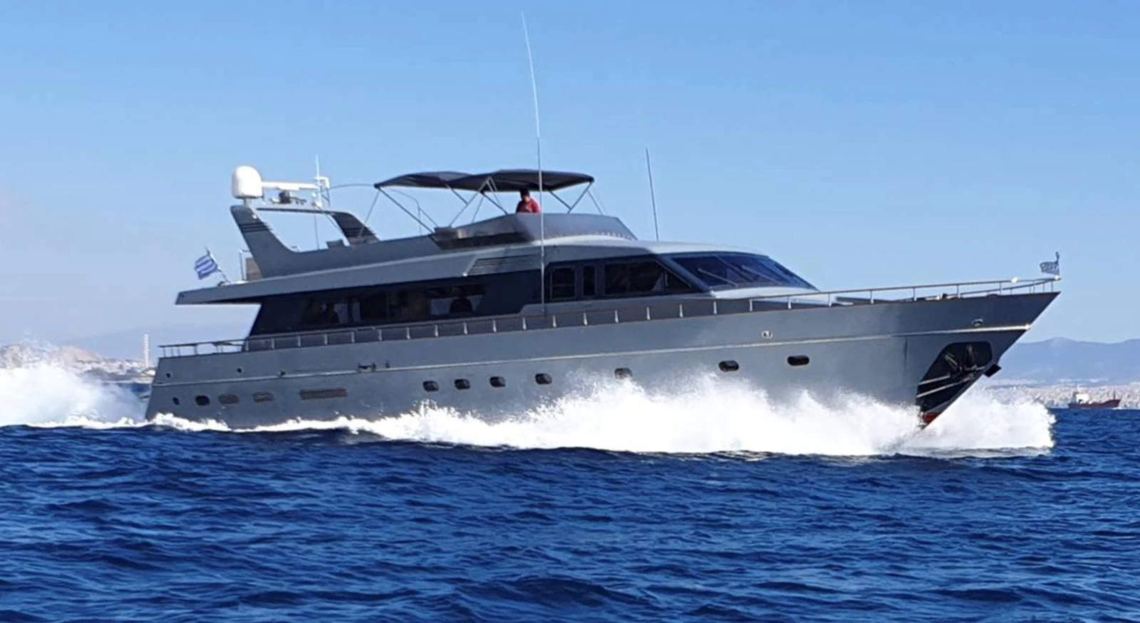 A sleek yacht cruises swiftly through the open water, showcasing its modern design and powerful performance. aboard KISS Yacht for Sale