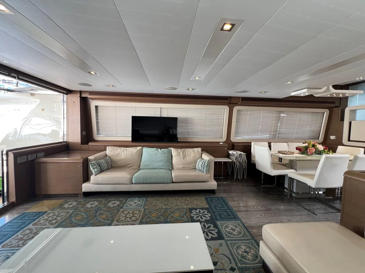 a living room with a large blue rug and white chairs aboard NGV Yacht for Sale