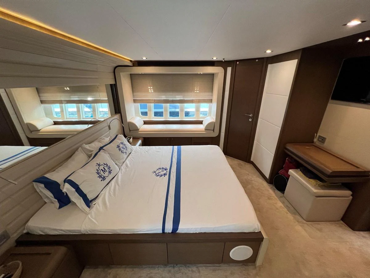 a room with a bed and a desk aboard NGV Yacht for Sale