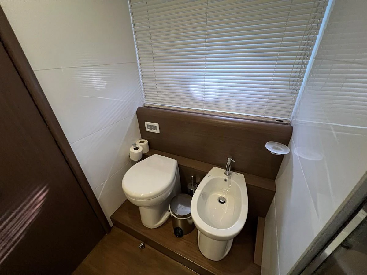 a bathroom with a toilet and a urinal aboard NGV Yacht for Sale