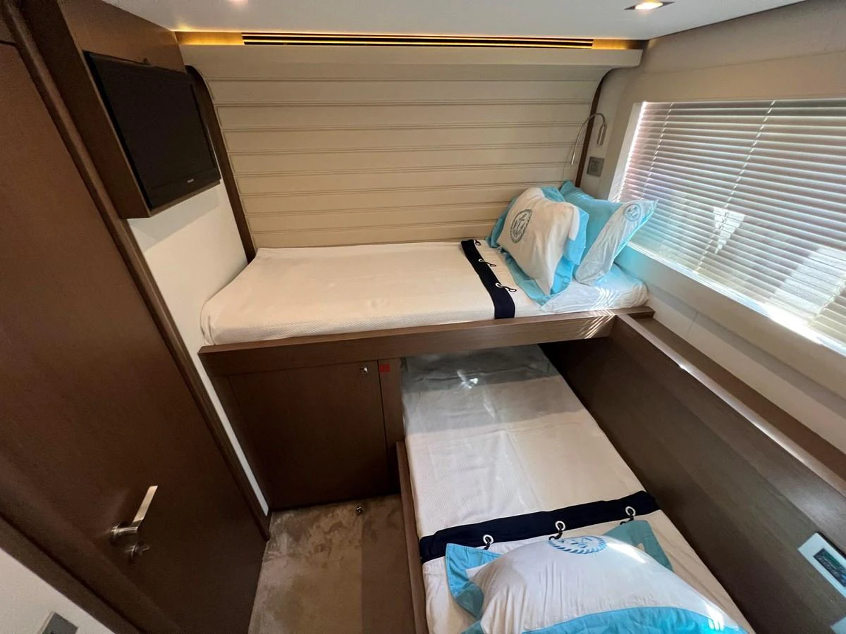 a room with a bed and a desk aboard NGV Yacht for Sale