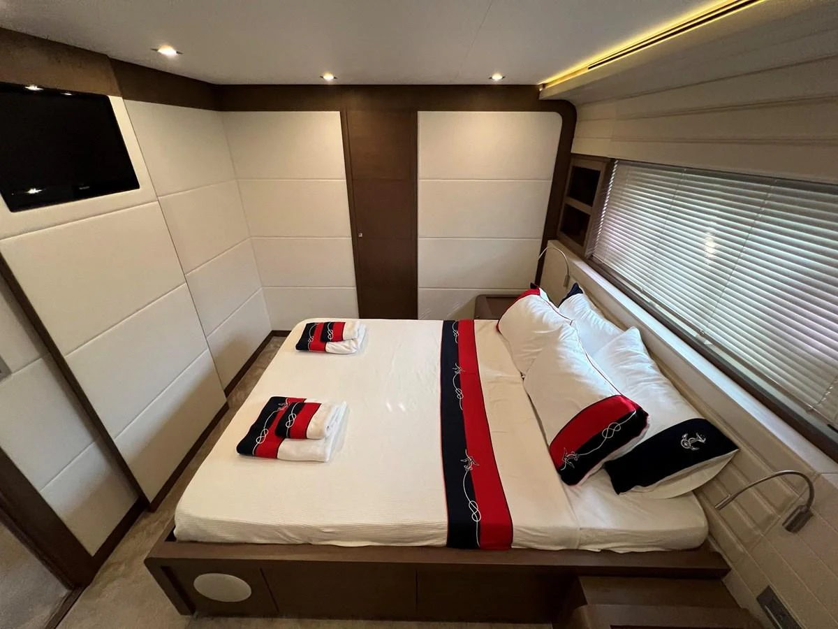 a room with a bed and desk aboard NGV Yacht for Sale