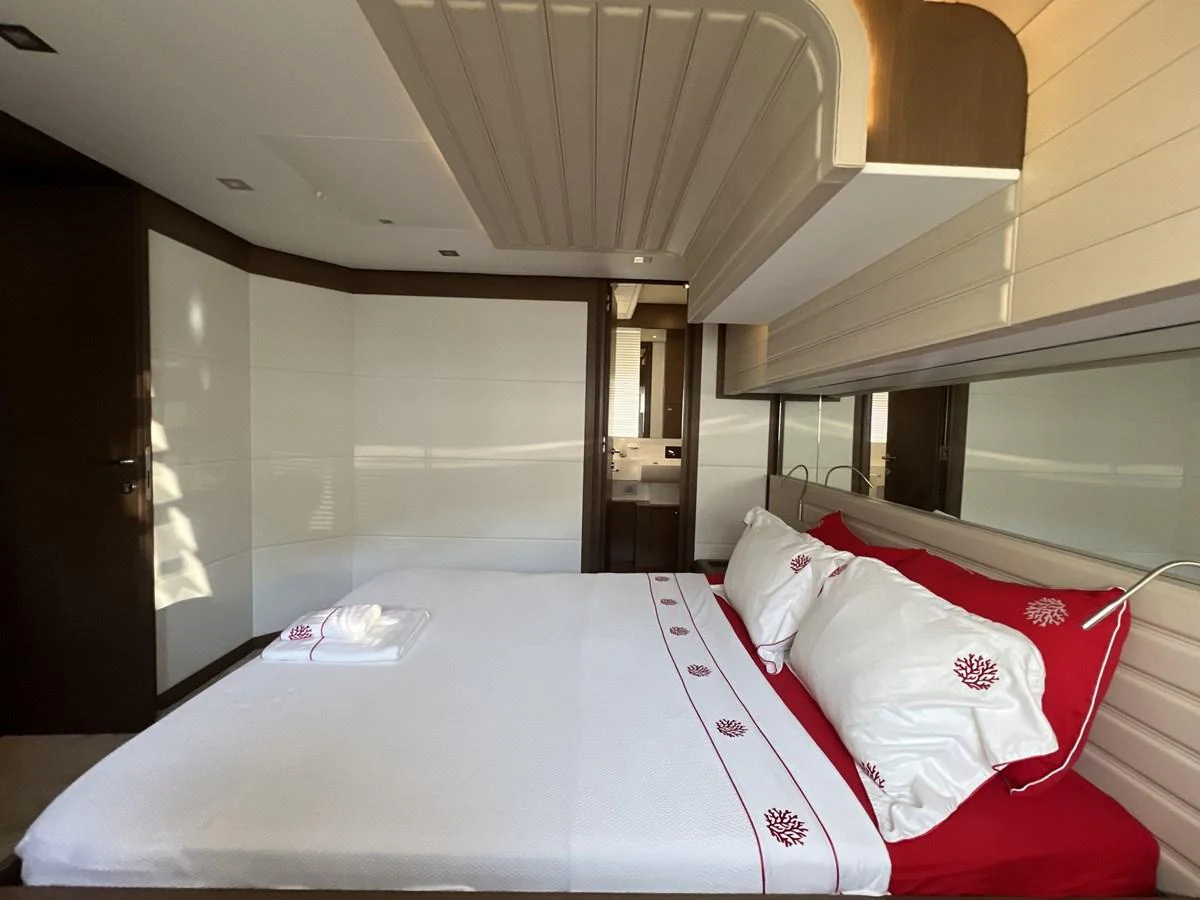 a room with a bed and a window aboard NGV Yacht for Sale