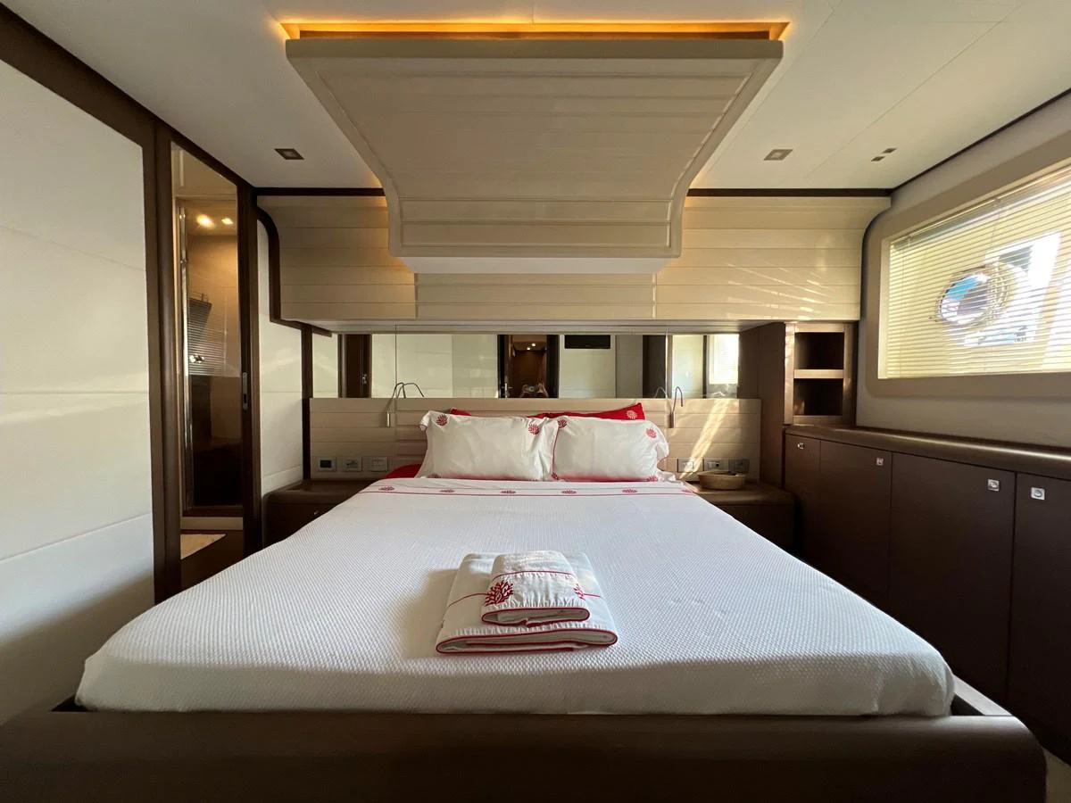 a bed with a white sheet and pillows on it aboard NGV Yacht for Sale