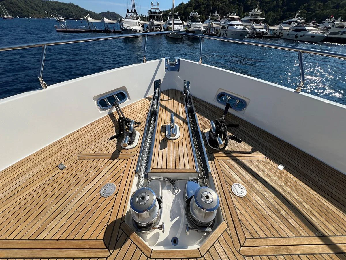 a wooden deck with a boat on it and a body of water in the background aboard NGV Yacht for Sale