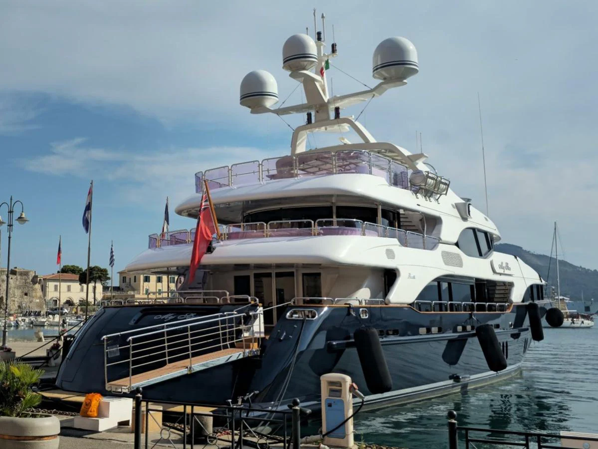 A luxurious yacht is docked at a marina, showcasing its sleek design and multiple decks. aboard MY SISA Yacht for Sale