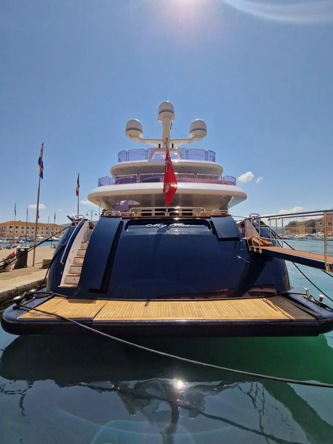 A luxurious yacht docked at a marina, showcasing its sleek design and multiple decks under a clear blue sky. aboard MY SISA Yacht for Sale