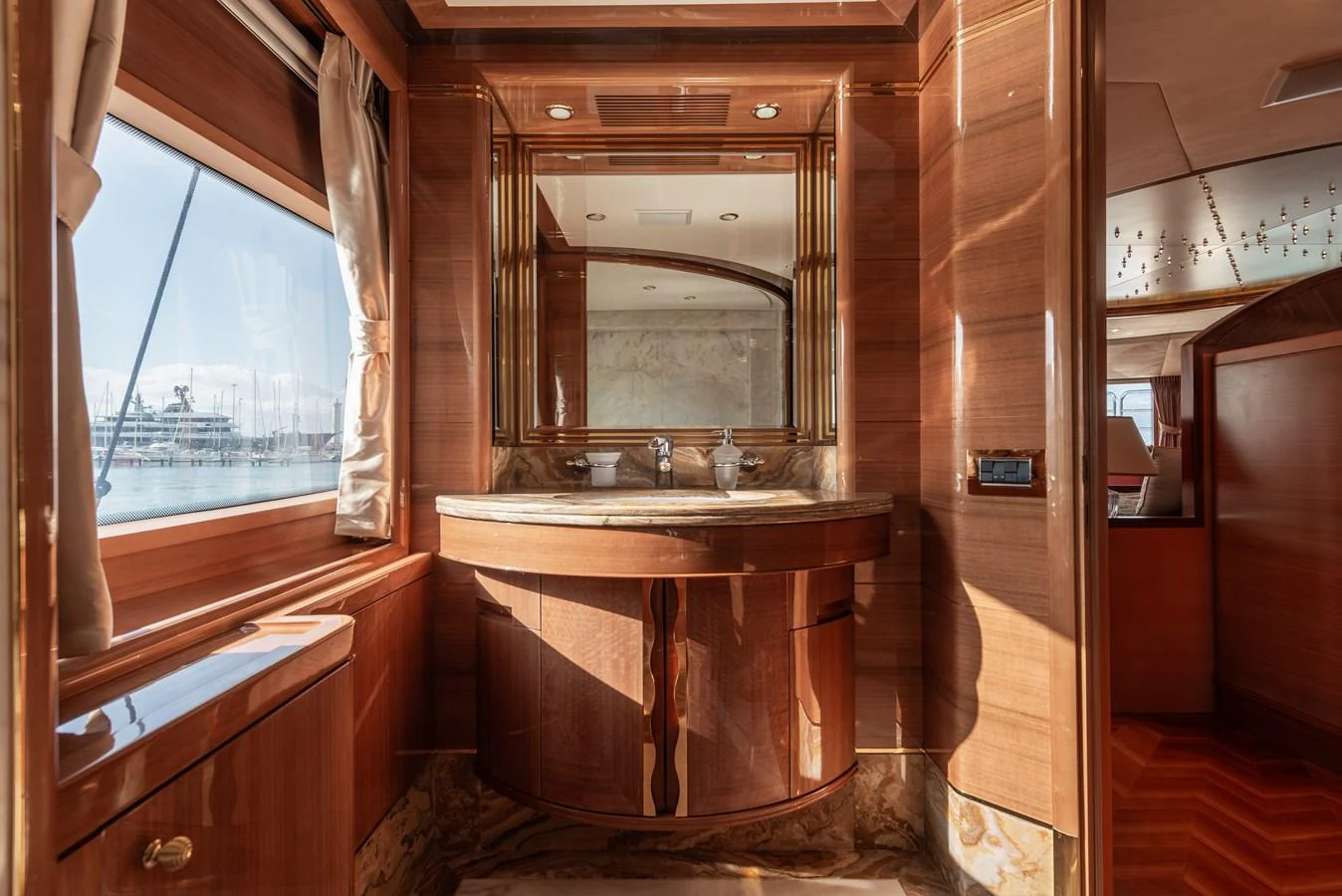 The yacht's bathroom features luxurious wood finishes and a large mirror, creating an elegant and spacious feel. aboard MY SISA Yacht for Sale