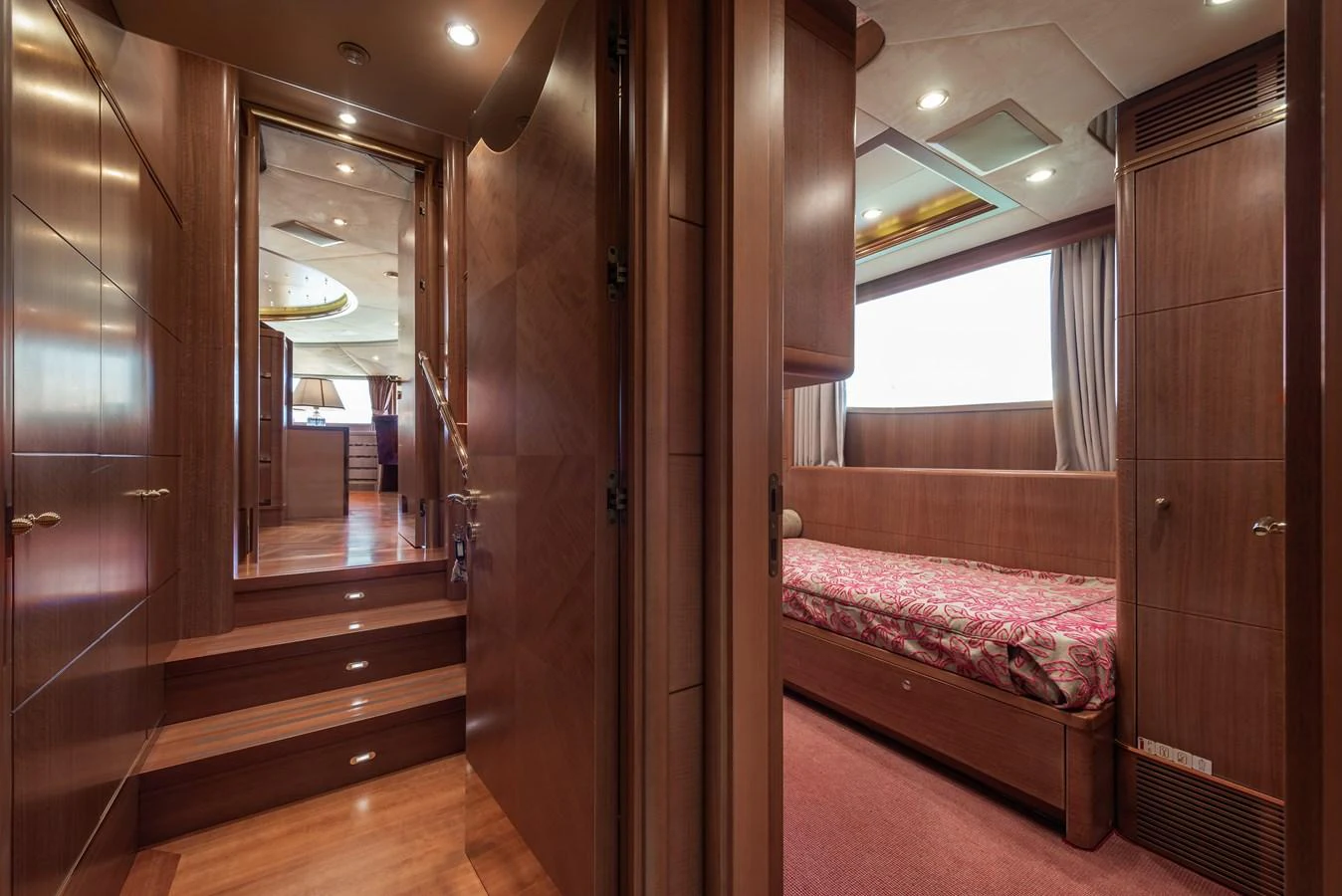 The image showcases a luxurious stateroom with rich wooden finishes and elegant decor. aboard MY SISA Yacht for Sale