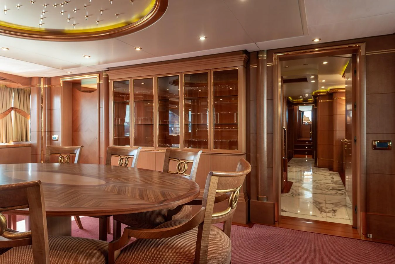 The yacht's dining area features elegant woodwork and a spacious table for gatherings. aboard MY SISA Yacht for Sale