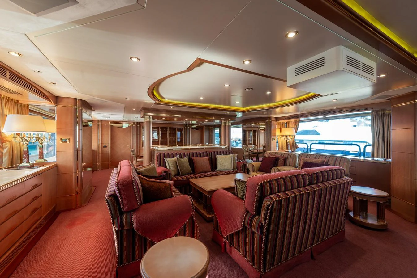 The yacht's salon features luxurious seating with rich wood accents and ample natural light. aboard MY SISA Yacht for Sale