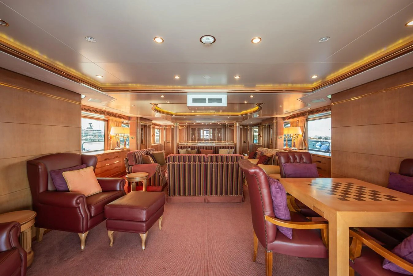 The salon features luxurious seating and a warm, inviting atmosphere with ample natural light. aboard MY SISA Yacht for Sale