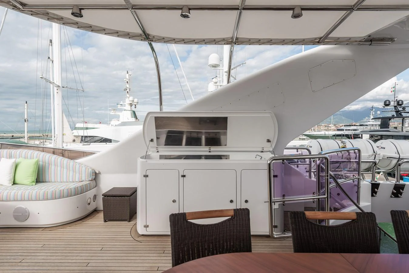 The aft deck features a comfortable seating area and a built-in grill, perfect for outdoor dining and relaxation. aboard MY SISA Yacht for Sale