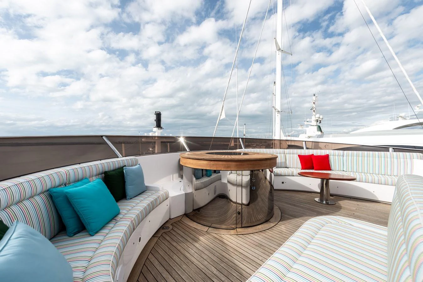 The flybridge offers a comfortable seating area with vibrant cushions and a central wooden table, perfect for relaxation and socializing. aboard MY SISA Yacht for Sale