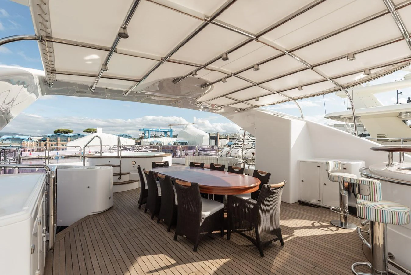 The aft deck features a spacious dining area with a large table and comfortable seating, perfect for alfresco meals. aboard MY SISA Yacht for Sale