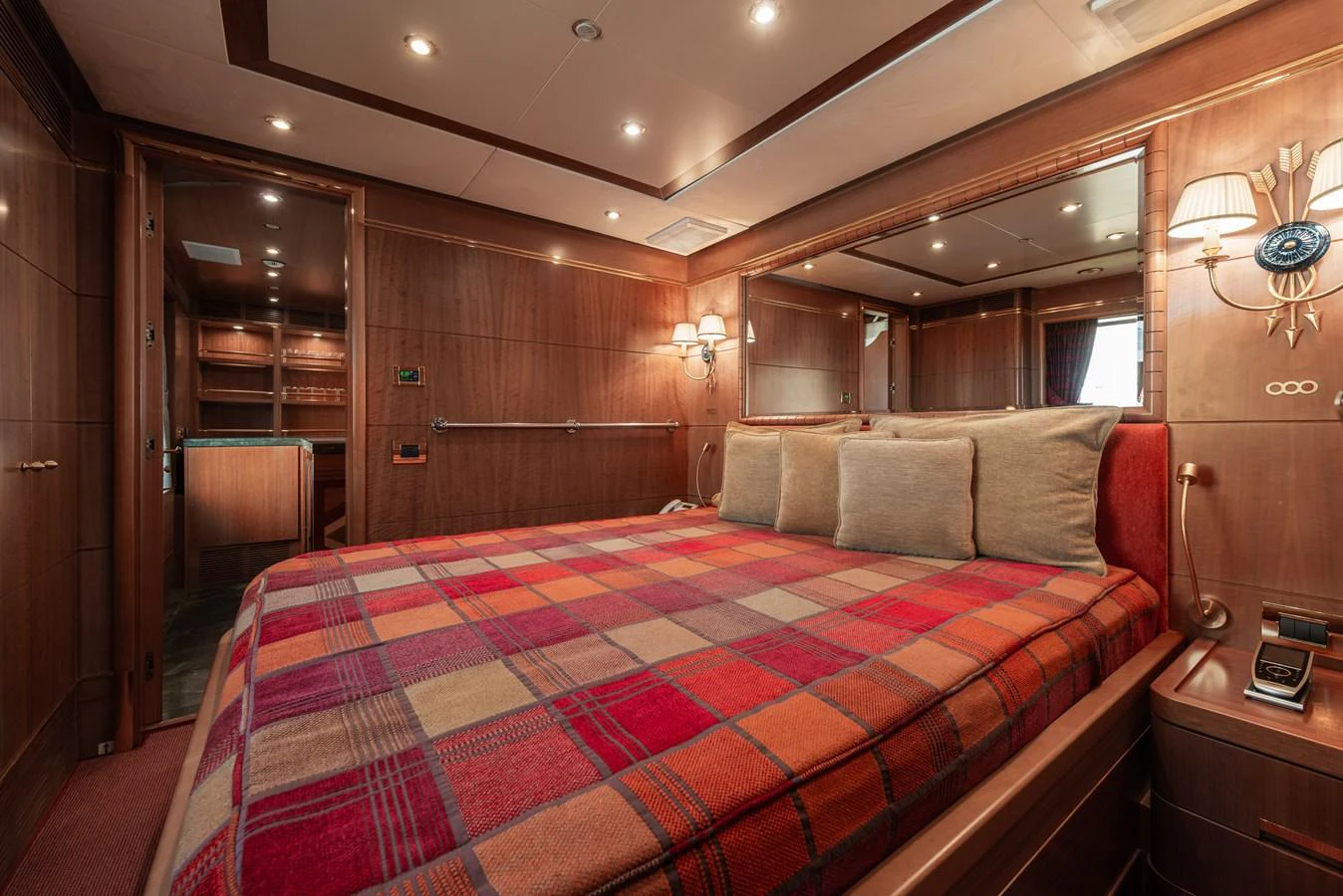 The stateroom features a cozy bed with a plaid blanket and warm wooden finishes. aboard MY SISA Yacht for Sale