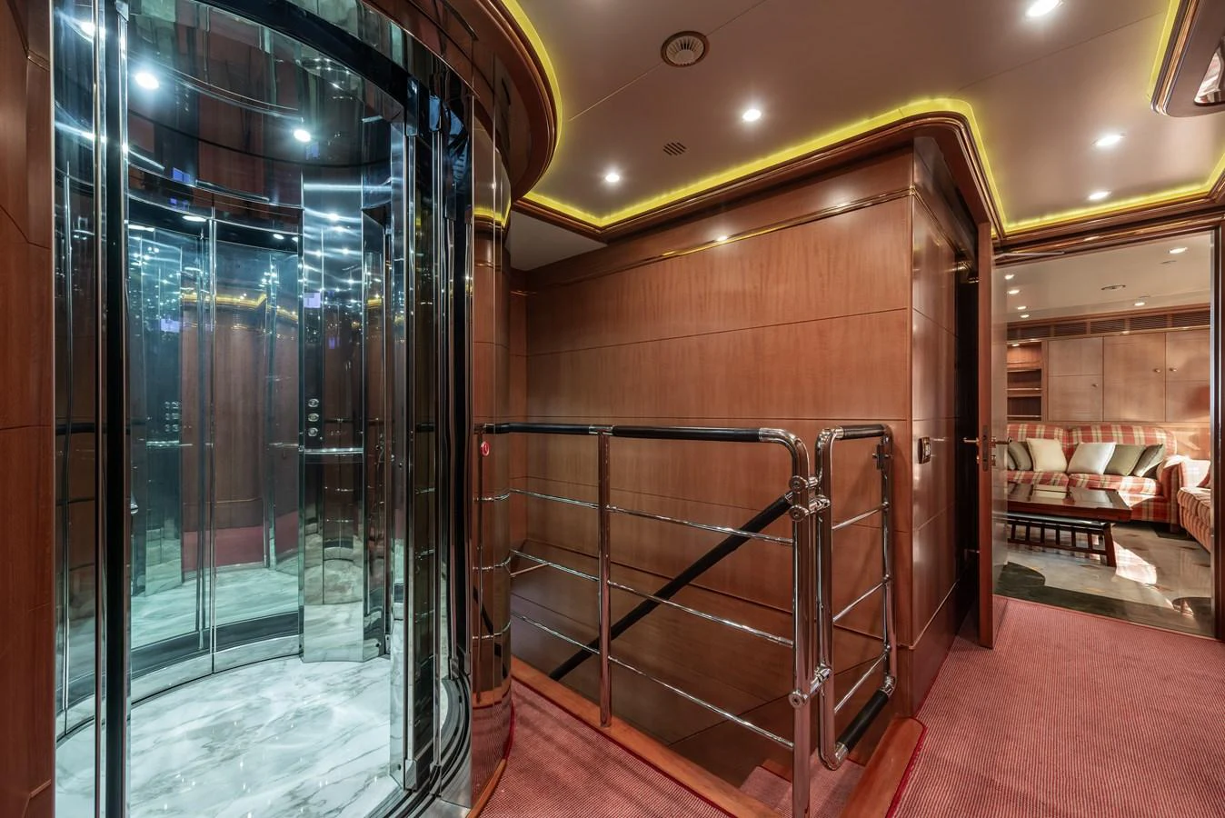 The yacht's interior features a luxurious elevator area with polished wood paneling and elegant lighting. aboard MY SISA Yacht for Sale