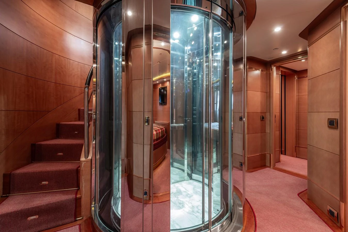 The yacht's interior features a luxurious elevator surrounded by elegant wood paneling and plush carpeting. aboard MY SISA Yacht for Sale