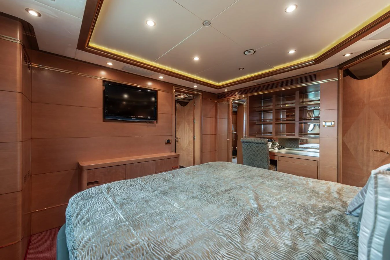 The master stateroom features elegant wood paneling, a plush bed, and modern amenities for ultimate comfort. aboard MY SISA Yacht for Sale