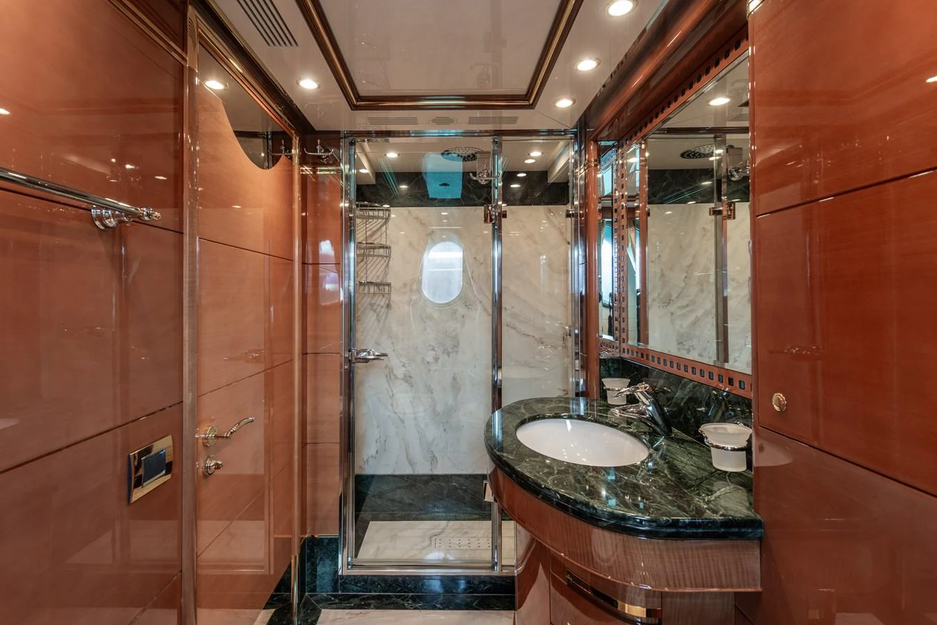 The yacht's bathroom features luxurious finishes with a marble shower and elegant wood paneling. aboard MY SISA Yacht for Sale