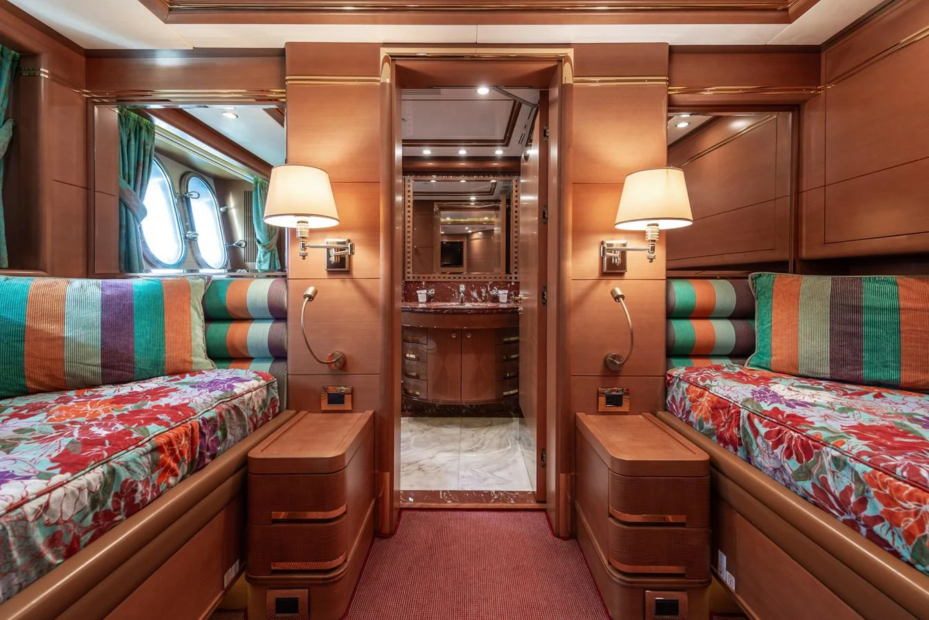 The guest stateroom features twin beds with vibrant bedding and elegant wooden furnishings. aboard MY SISA Yacht for Sale