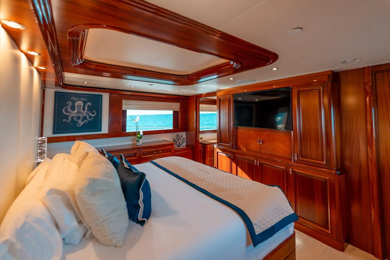 a bedroom with a bed and a wood cabinet aboard BLUE TIME Yacht for Sale