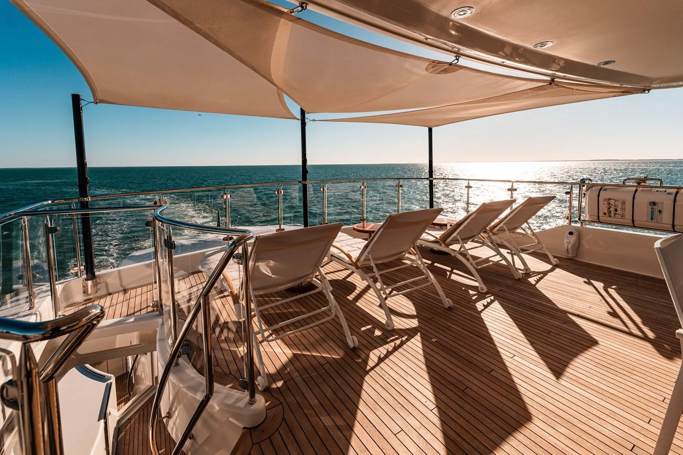 a deck with chairs and a body of water aboard BLUE TIME Yacht for Sale