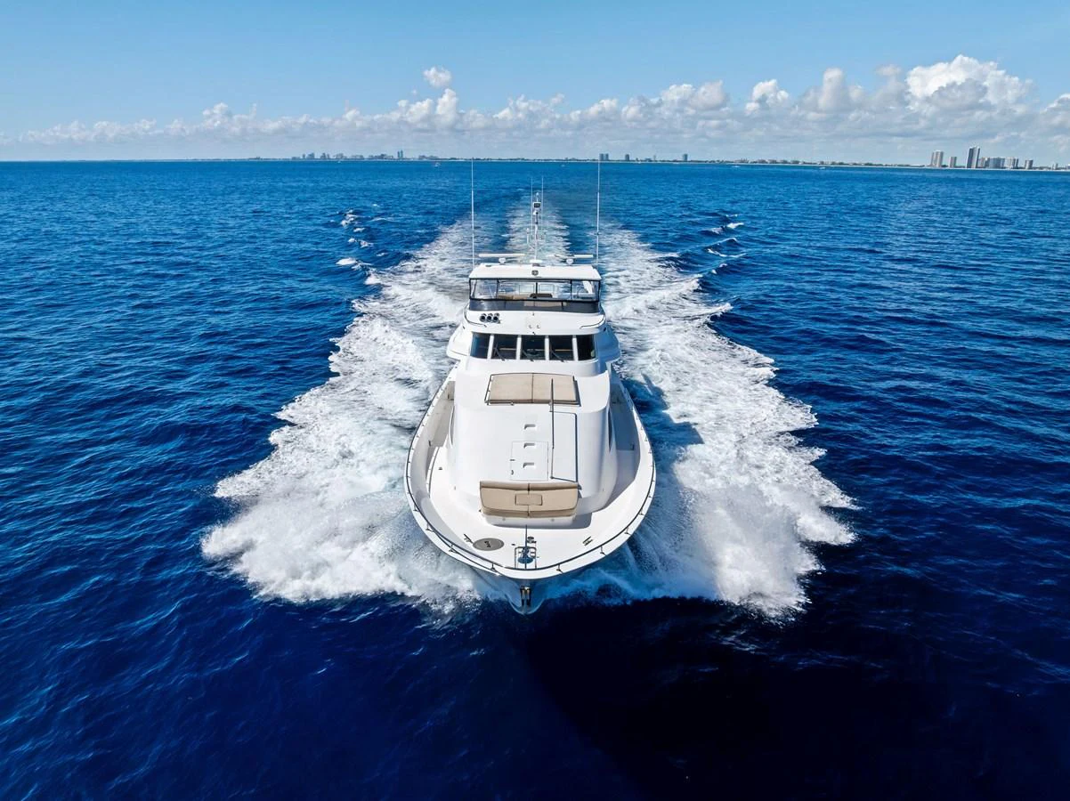 A luxurious yacht cruises swiftly through the open sea, leaving a trail of white wake behind. aboard BRAVO ZULU Yacht for Sale