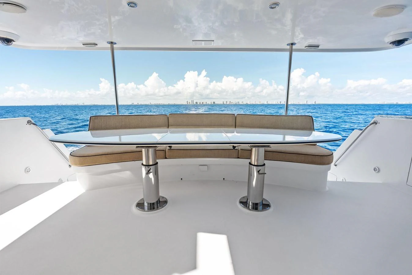 The aft deck features a sleek dining area with panoramic ocean views. aboard BRAVO ZULU Yacht for Sale