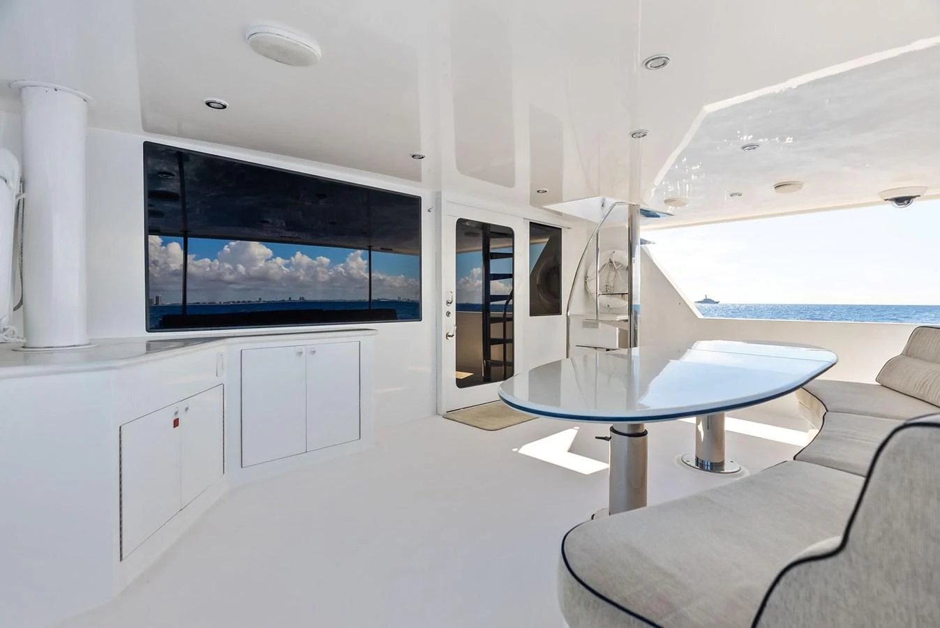 The aft deck offers a spacious and modern area with comfortable seating and a large TV, perfect for relaxation and entertainment. aboard BRAVO ZULU Yacht for Sale