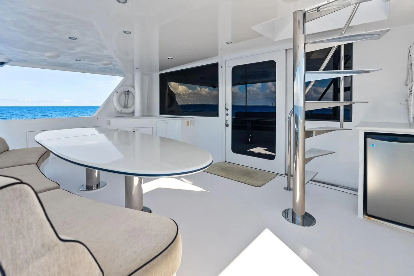 The aft deck features a sleek, modern design with comfortable seating and a stylish spiral staircase. aboard BRAVO ZULU Yacht for Sale