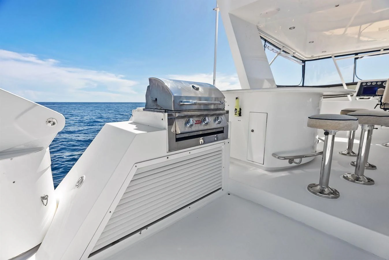 The yacht features a sleek outdoor galley with a stainless steel grill and bar seating, perfect for alfresco dining. aboard BRAVO ZULU Yacht for Sale