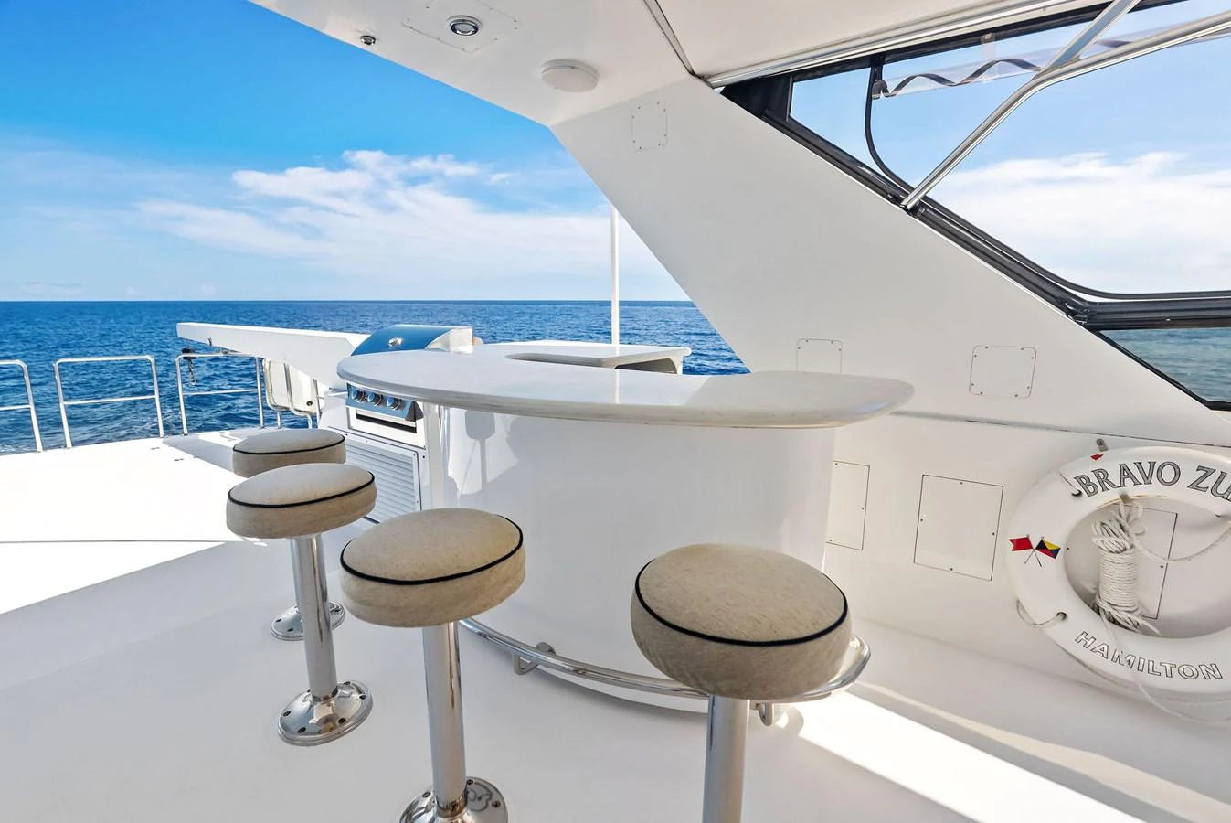 The yacht features a sleek outdoor bar area with a stunning ocean view. aboard BRAVO ZULU Yacht for Sale