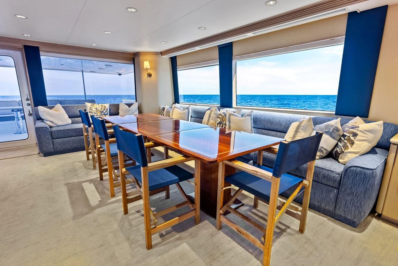 The yacht's dining area features a polished wooden table surrounded by comfortable seating with ocean views. aboard BRAVO ZULU Yacht for Sale