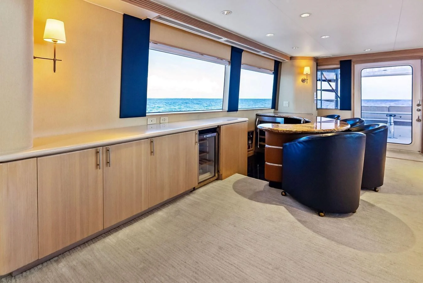 The salon features a spacious seating area with large windows offering stunning ocean views. aboard BRAVO ZULU Yacht for Sale
