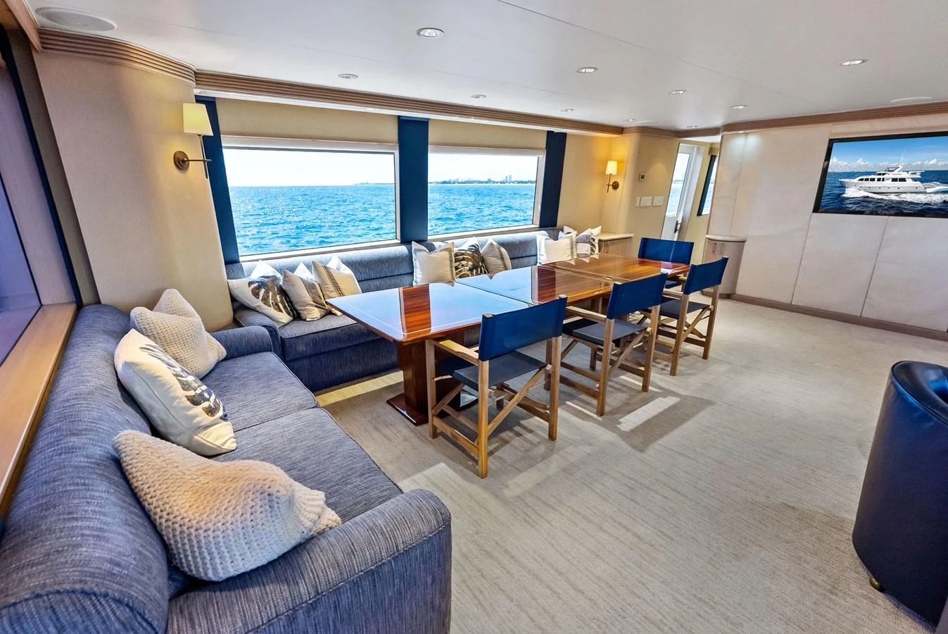 The yacht's salon features a spacious seating area with a dining table and large windows offering stunning ocean views. aboard BRAVO ZULU Yacht for Sale