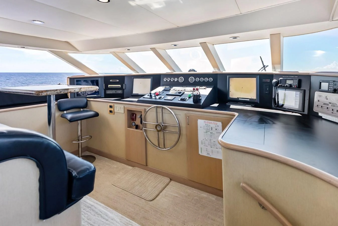 The helm station offers a commanding view with modern navigation equipment and a comfortable seating area. aboard BRAVO ZULU Yacht for Sale
