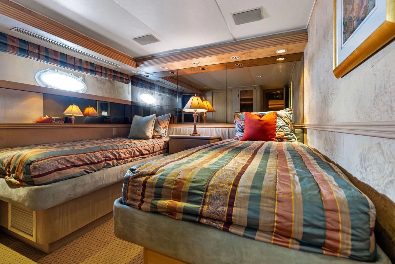 The twin stateroom offers a cozy and inviting space with two comfortable beds and warm lighting. aboard BRAVO ZULU Yacht for Sale