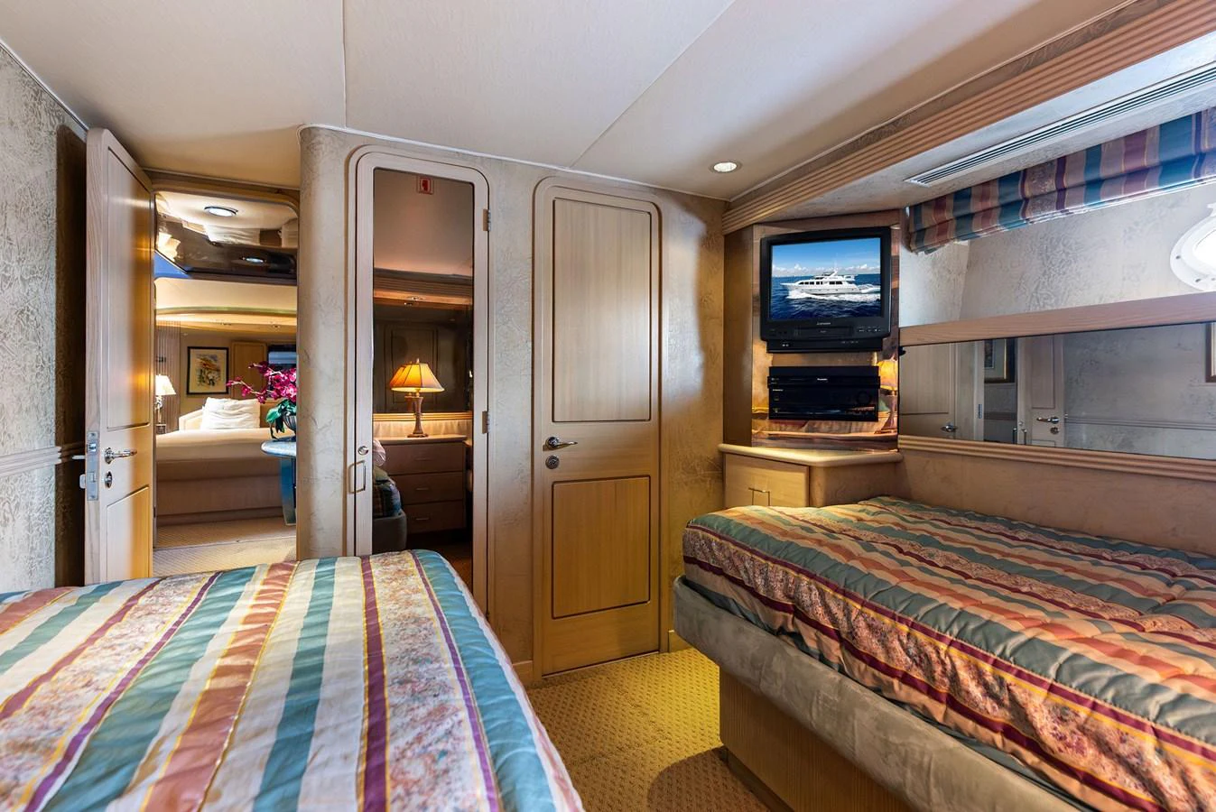 The guest stateroom features twin beds, a television, and a view into an adjoining room. aboard BRAVO ZULU Yacht for Sale