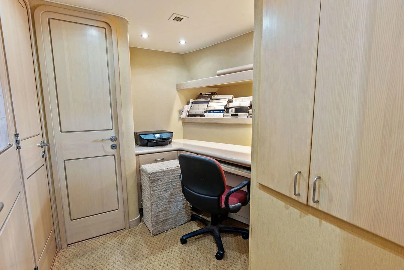 A cozy yacht office space with a desk, chair, and storage cabinets. aboard BRAVO ZULU Yacht for Sale
