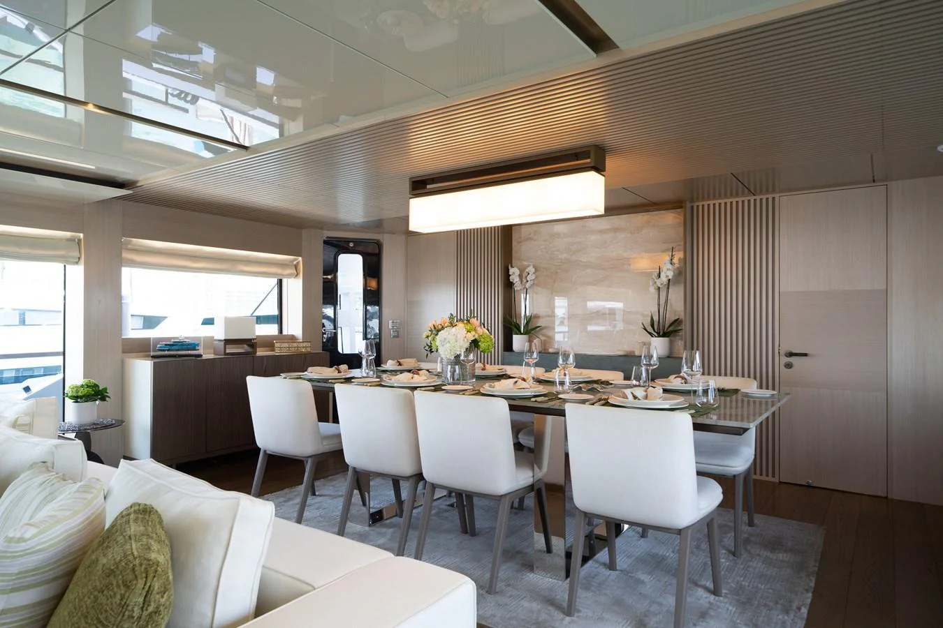 The yacht's dining area features a modern and elegant setup with a large table and comfortable seating. aboard M/Y MASHA Yacht for Sale