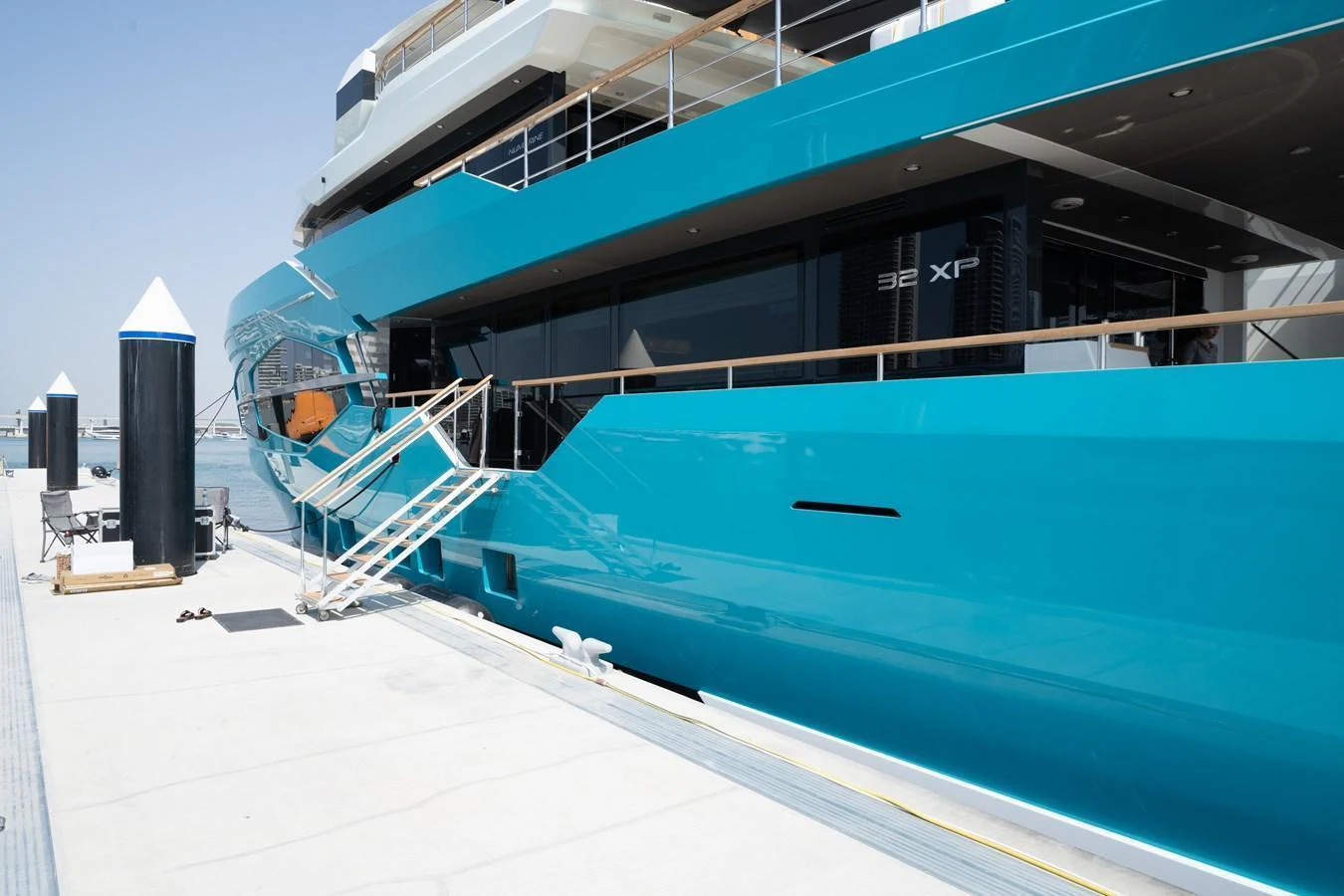 A sleek, modern yacht docked at a marina, showcasing its vibrant blue hull and elegant design. aboard M/Y MASHA Yacht for Sale