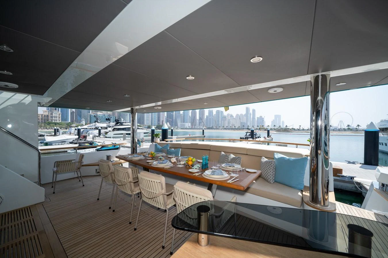 The aft deck offers a luxurious dining area with a stunning cityscape view. aboard M/Y MASHA Yacht for Sale