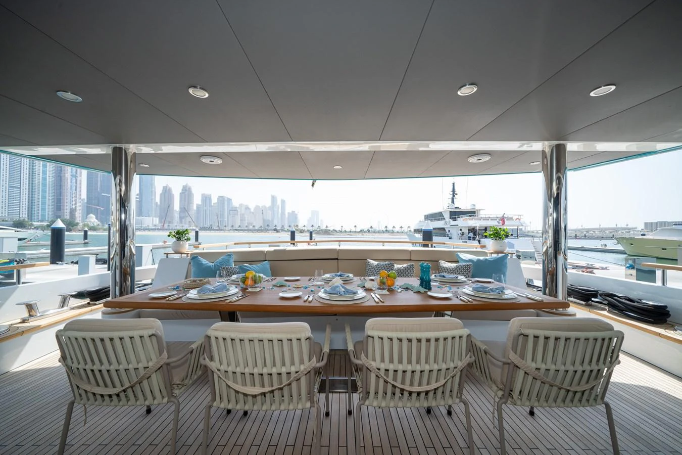 The aft deck features an elegant dining area with a stunning cityscape view. aboard M/Y MASHA Yacht for Sale