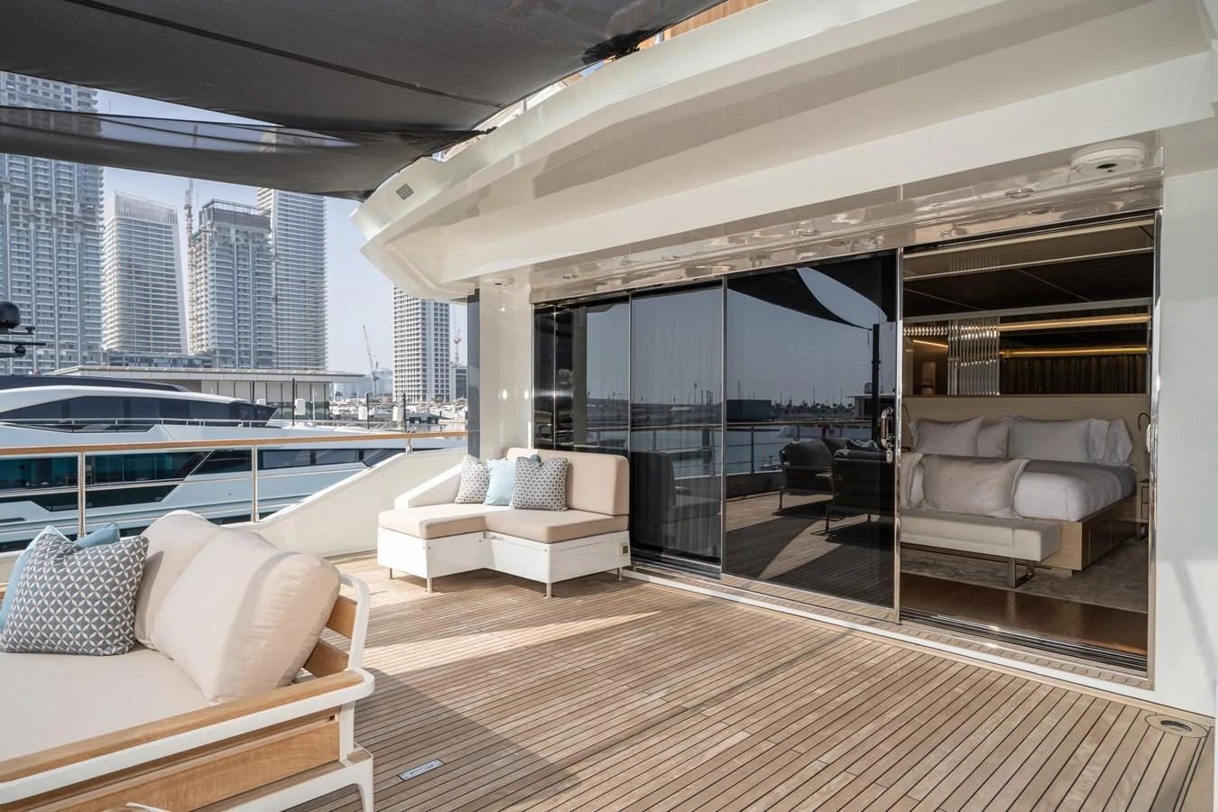 The aft deck features a comfortable seating area with a view of the marina and access to the interior stateroom. aboard M/Y MASHA Yacht for Sale