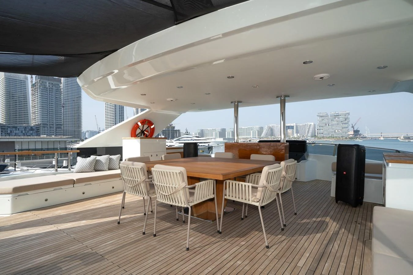 The aft deck features a spacious dining area with a large wooden table and comfortable seating, perfect for outdoor meals and gatherings. aboard M/Y MASHA Yacht for Sale